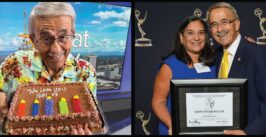 man with a cake and accepting award with his wife