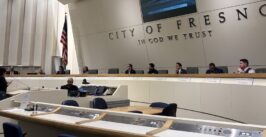 a person speaks to a city council dais gathering of members