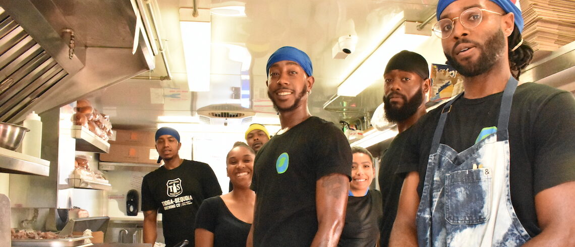 people posing for a photo inside a food truck