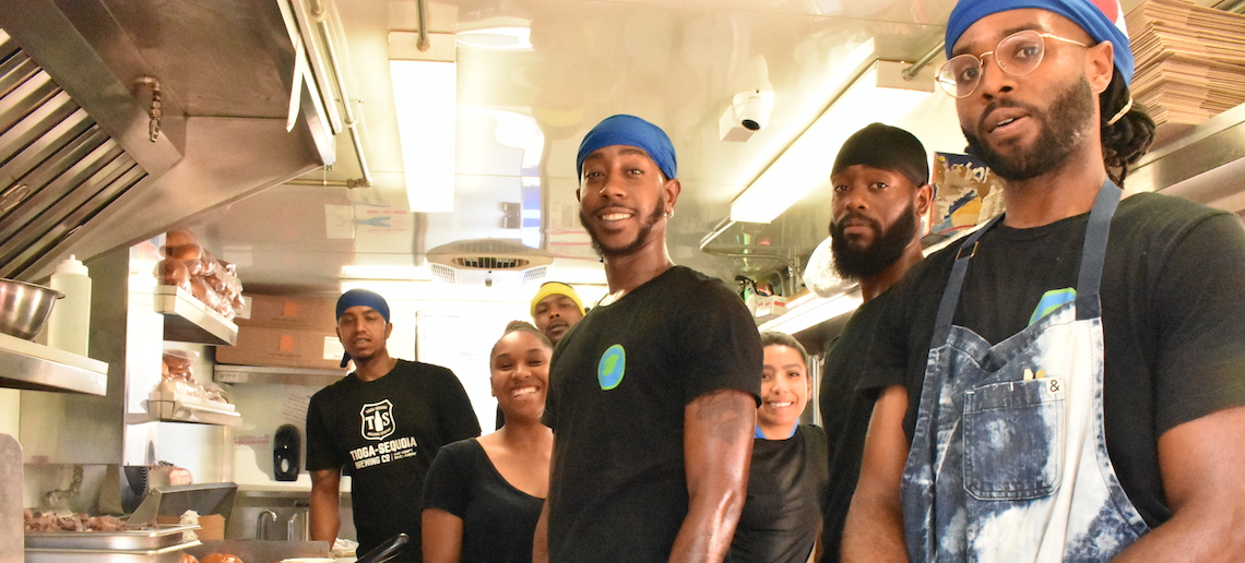 people posing for a photo inside a food truck
