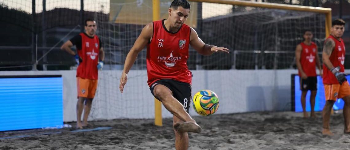 beach soccer player dribbling ball