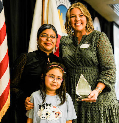 two women and a young girl pose near a us flag