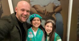 man posing with two girl scouts