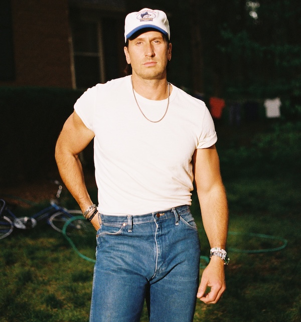 man wearing blue jeans, white shit and ballcap