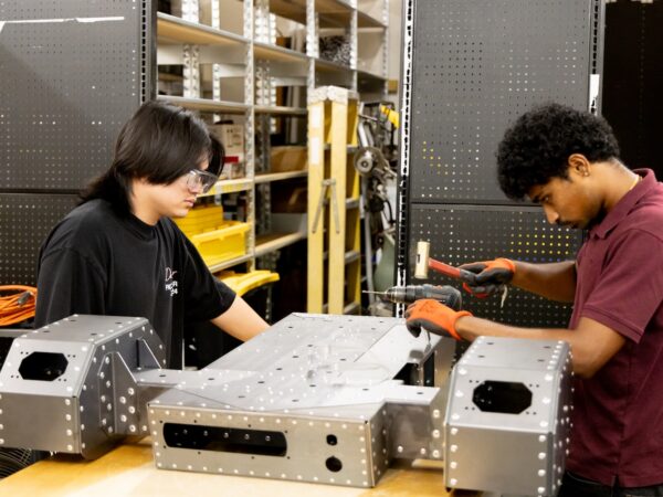 two young people repairing an ag robotics system