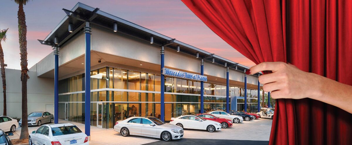 luxury auto dealership behind a red curtain with a hand extended