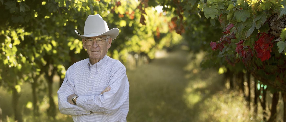 man in a cowboy hat in a vineyard