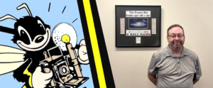 man stands next to a fresno bee framed page