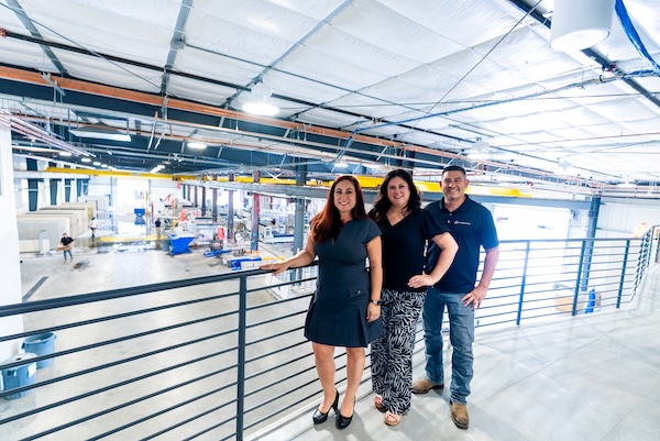 three people on top of floor of fabrication workshop