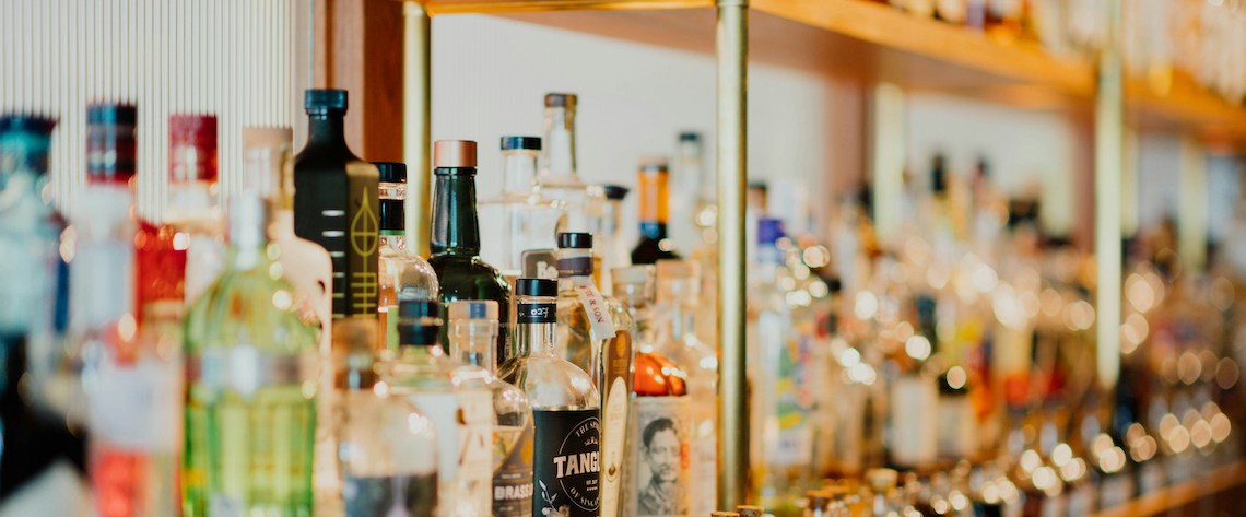 Close up of a shelf of alcohol bottles