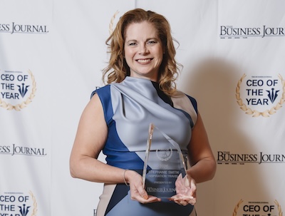 woman smiling and holding award