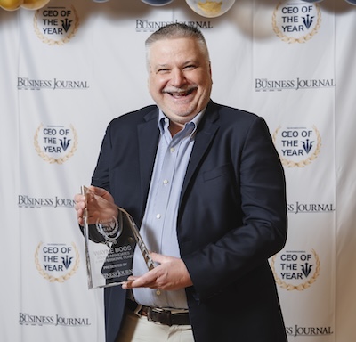 man smiling while holding award