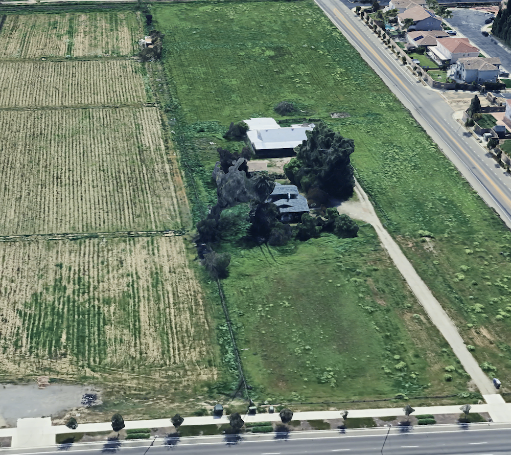 aerial view of a field with an old home