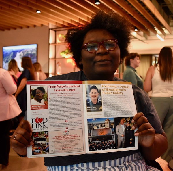 woman holds up a publication