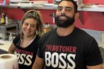 two people behind a butcher counter