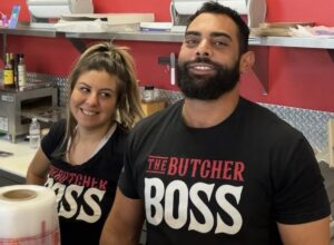 two people behind a butcher counter