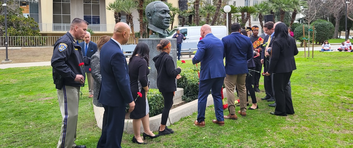 a gathering of people at a martin luther king, jr. statue at a greenspace