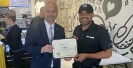two men posing and holding a certificate