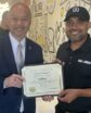 two men posing and holding a certificate