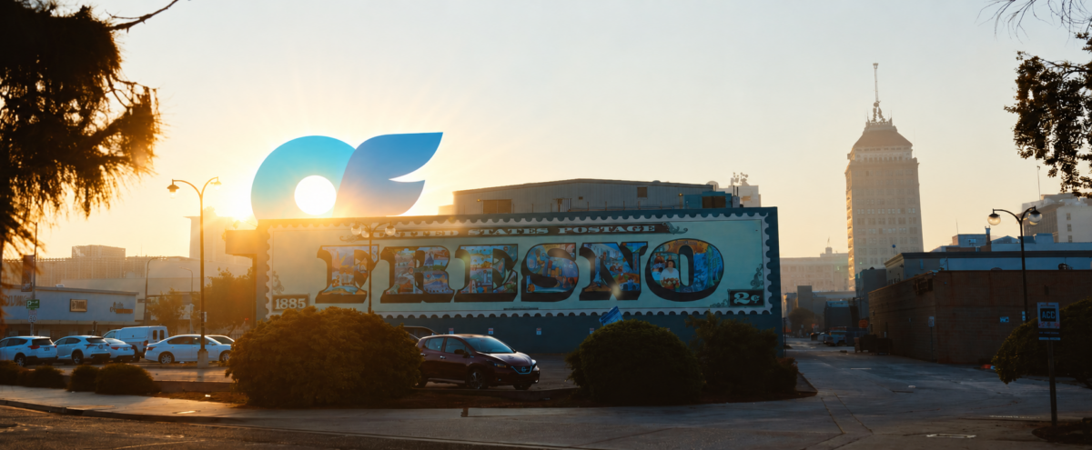 a building with a mural with sunrise and an only fans logo rising over the building