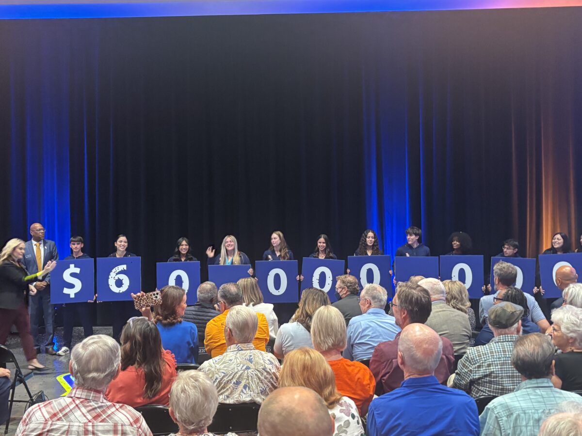 Fresno Pacific University students hold signs displaying $60 million during an announcement of a record gift from an anonymous alumnus.