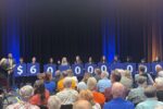 Fresno Pacific University students hold signs displaying $60 million during an announcement of a record gift from an anonymous alumnus.