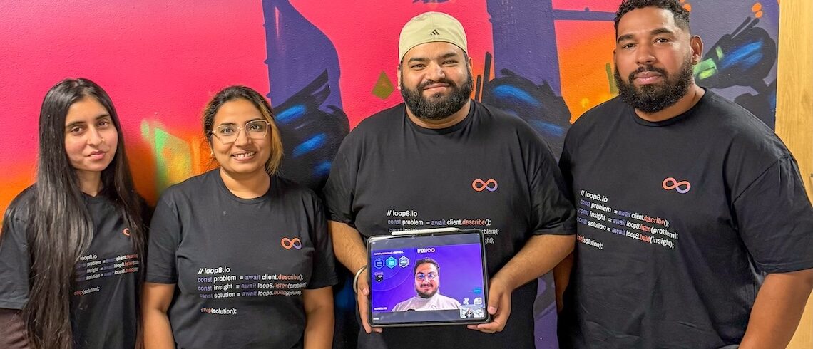 a tech company team consisting of two women and two men, plus a man's face on a tablet