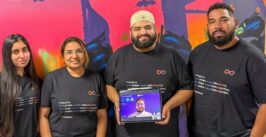 a tech company team consisting of two women and two men, plus a man's face on a tablet