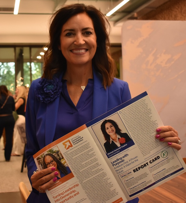 woman holds up a publication