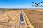 Aerial view of Eagle Field’s runway near Firebaugh, California, surrounded by agricultural land, with an AI-enhanced image and ASKA company logo overlaid in the sky.