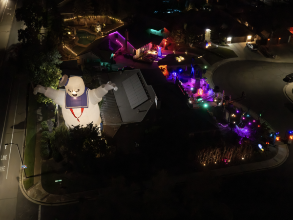 A giant inflatable Stay Puft Marshmallow Man stands beside a Visalia home decorated for Halloween.