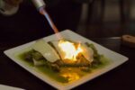 burrito with cheese being melted by a torch